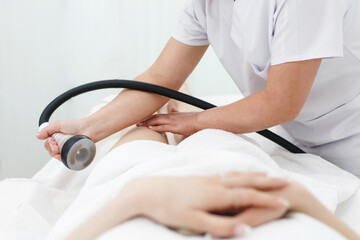 RF body cavitation lifting procedure in a beauty salon. Ultrasound therapy to reduce fat and elasticity of the skin. Cosmetic ultrasonic anti-cellulite massage close-up