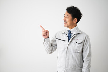 指差しをするミドル男性　作業服イメージ
