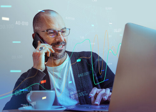 a happy businessman talking on the phone with his laptop in a tech-savvy business environment