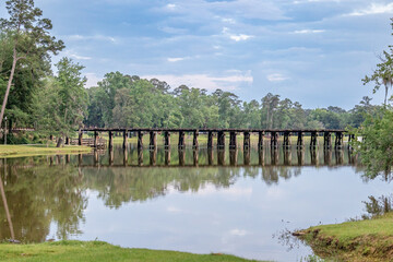 Serene and peaceful railroad track bridge over a public lake called Cherokee Lake, in Thomasville Georgia on a sunny day