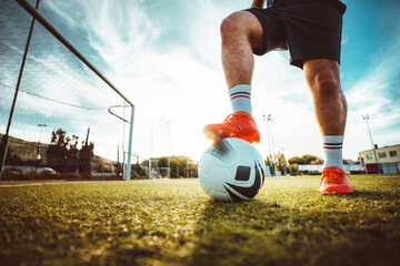 Professional football kicking ball in soccer stadium - Athletic man training sport outside -...
