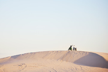 Desert blue sky, motorbike and sports people high five, excited celebrate travel, teamwork or off...