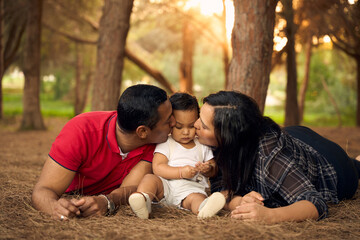 Fototapeta premium A beautiful family in a park with a one-year-old child