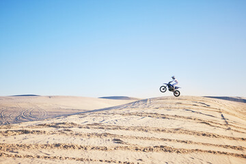 Desert, bike jump or sports person travel, agile and air trick on sand hill adventure, exercise or...