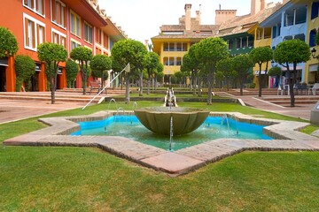 square with fountain and colorful houses in Sotogrande at the Mediterranean Sea, Cádiz, Andalusia,...