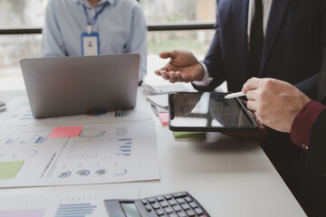 Businessman is reviewing monthly sales documents for analysis and marketing plans for more sales growth, they are the founders of young companies co-founding startups. Sales management concept.