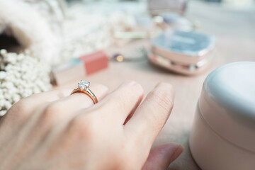 Close up of diamond ring on woman’s finger with sunlight and shadow. Love, valentine,...