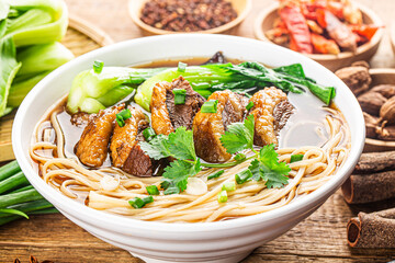 Spicy red soup beef noodle in a bowl on wooden table