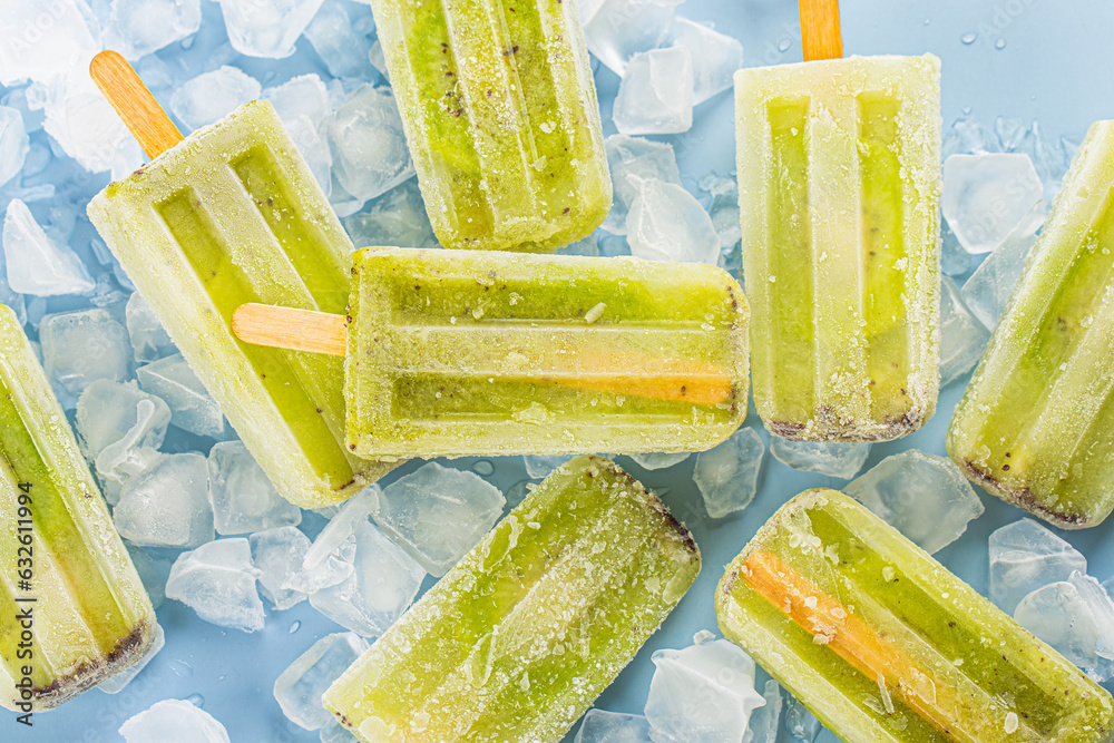 Poster Kiwi ice cream popsicle on top of wooden board background