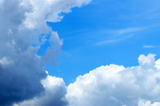夏の澄んだ青空と迫る白い雲、雷雨を予感させるコントラストがはっきりした背景画像