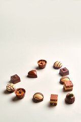 Heart shape made with various types of chocolate truffles over a white table