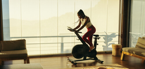 Athletic black woman exercising with fitness equipment at home