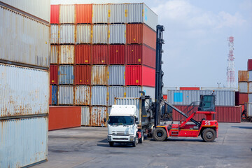 forklift truck Container boxes in a logistic yard with a stack of containers in the background.