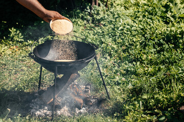 cooking in cauldron in rural landscape, cooking in the hike, outdoor activities. Preparation of...