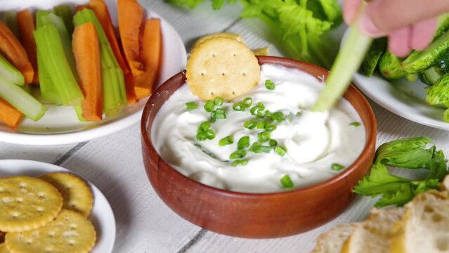 Cottage cheese high-protein dip with fresh vegetables, bread and crackers on wooden white table copy space. Eating diet healthy curd cheese spread with various snacks