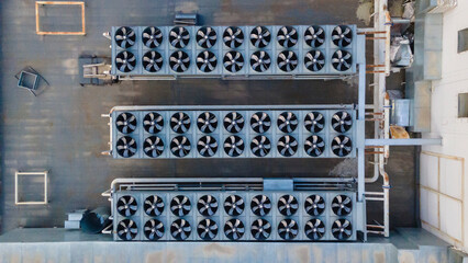 Three rows of fan coils on the roof of a building - obrazy, fototapety, plakaty