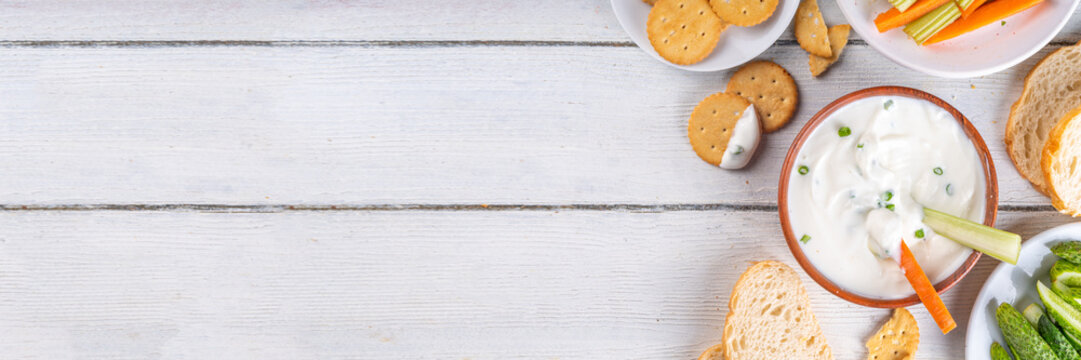 Cottage cheese high-protein dip with fresh vegetables, bread and crackers on wooden white table copy space. Eating diet healthy curd cheese spread with various snacks - Powered by Adobe