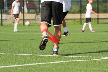 warm-up of a football player with the help of a sports elastic band. © Olena Yefremkina