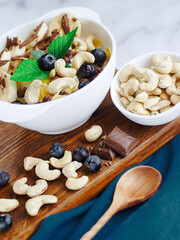 Banana salad with chocolate and cashew nuts in yogurt in a white plate. View from above. Healthy nutritious breakfast.