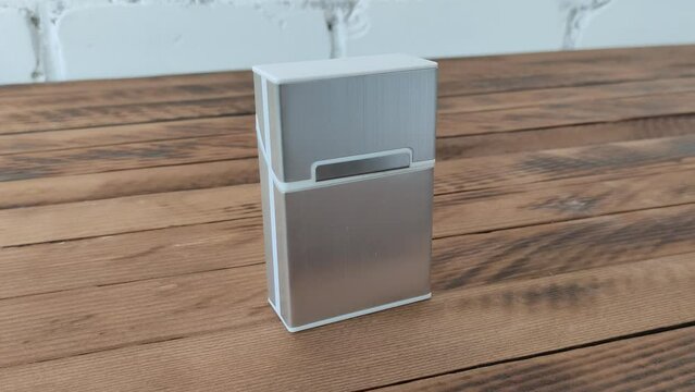 Metal cigarette case on wooden background