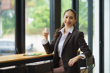 Beautiful young Asian woman having a relaxing time enjoying coffee in a cafe.