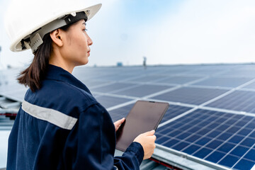 Woman engineer electrician using a hand to check solar panels on the roof, clean energy power...