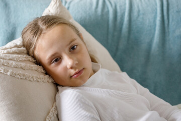 Little child girl lying on bed at home, close up portrait