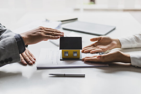 Businessmen, real estate agents discuss house purchase prices, fee, mortgage, interest, rent, cash flow, loan. Negotiate for businessmen to legally sign home purchase agreements contract , lease.