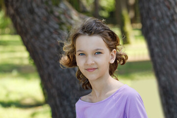 Happy kid in summer park, face closeup. Girl 8 years old