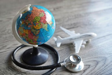 Selective focus image of globe, toy plane and stethoscope. Medical tourism concept