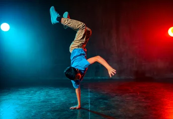 Boy breakdancing in dark studio with lights