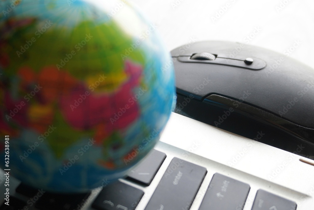 Wall mural close up image of globe, laptop keyboard and computer mouse. internet, globalization and technology 