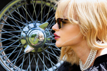 profile portrait of a beautiful blond woman set against the hub and spokes of the sports wheel of...