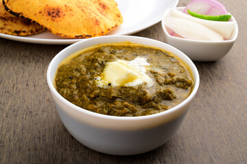 Saag with white butter in bowl at dinner table