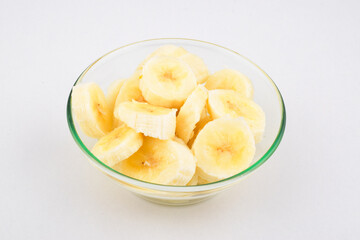 Closeup of sliced banana in bowl isolated on white background