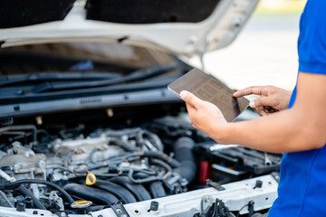 Automotive mechanic repairmen use tablets and check the system working engine of the engine room,...