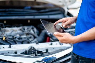 Automotive mechanic repairmen use tablets and check the system working engine of the engine room, check the mileage of the car, oil change, auto maintenance service concept. - obrazy, fototapety, plakaty