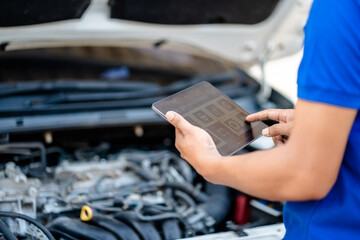 Automotive mechanic repairmen use tablets and check the system working engine of the engine room,...