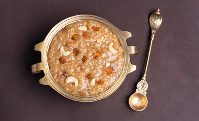 Kerala food sweets dessert Sarkara Payasam or Ari Payasam in golden bowl isolated on brown colour background