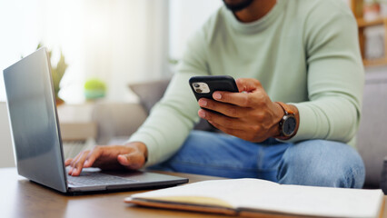 Phone, laptop and man hands typing while doing research for a freelance project in his living room. Technology, keyboard and male freelancer working online with a computer and cellphone at his home.