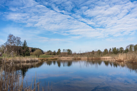 Beautiful lake landscape with light clouds and reflection in spring