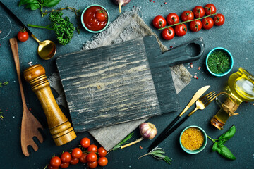 Wooden cutting board and spices, herb for food on black stone table. Menu, recipe mock up, banner...