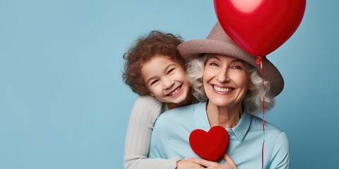 An elderly gray-haired woman in a hat and stylish outfit hugs a small child, holds a red helium balloon, feels happy.