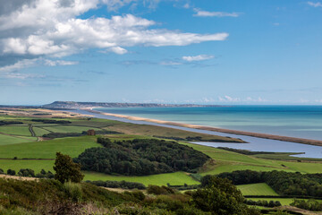 A view of Chesil Beach with Portland Bill in the distance, viewed from near Abbotsbury, on a sunny summer's day