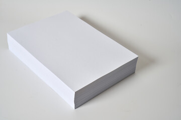 Pile of white and blank a4 paper on a white surface