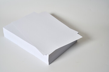 Pile of white and blank a4 paper on a white surface