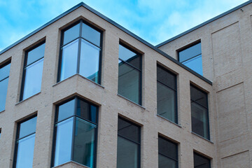 Modern office building in scandinavia with blue cloudy skies in the background.
