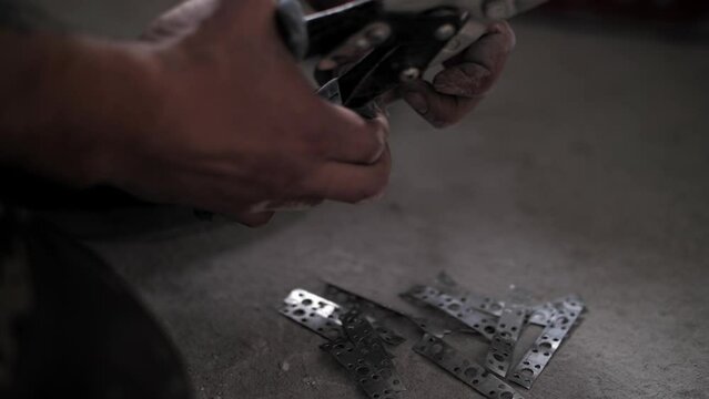 Builder uses metal scissors. Renovation in the apartment.