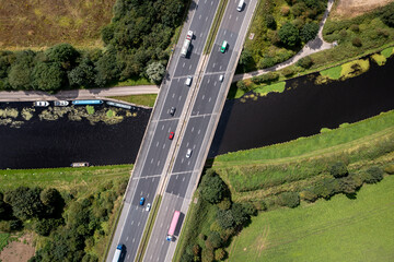 Aerial view directly above a busy UK motorway bridge over a river