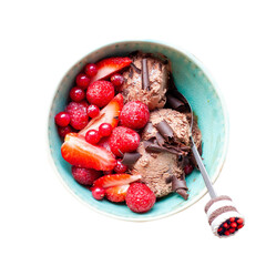 Sweet chocolate ice cream in bowl on rustic wooden background with slices of fresh strawberry, flatlay